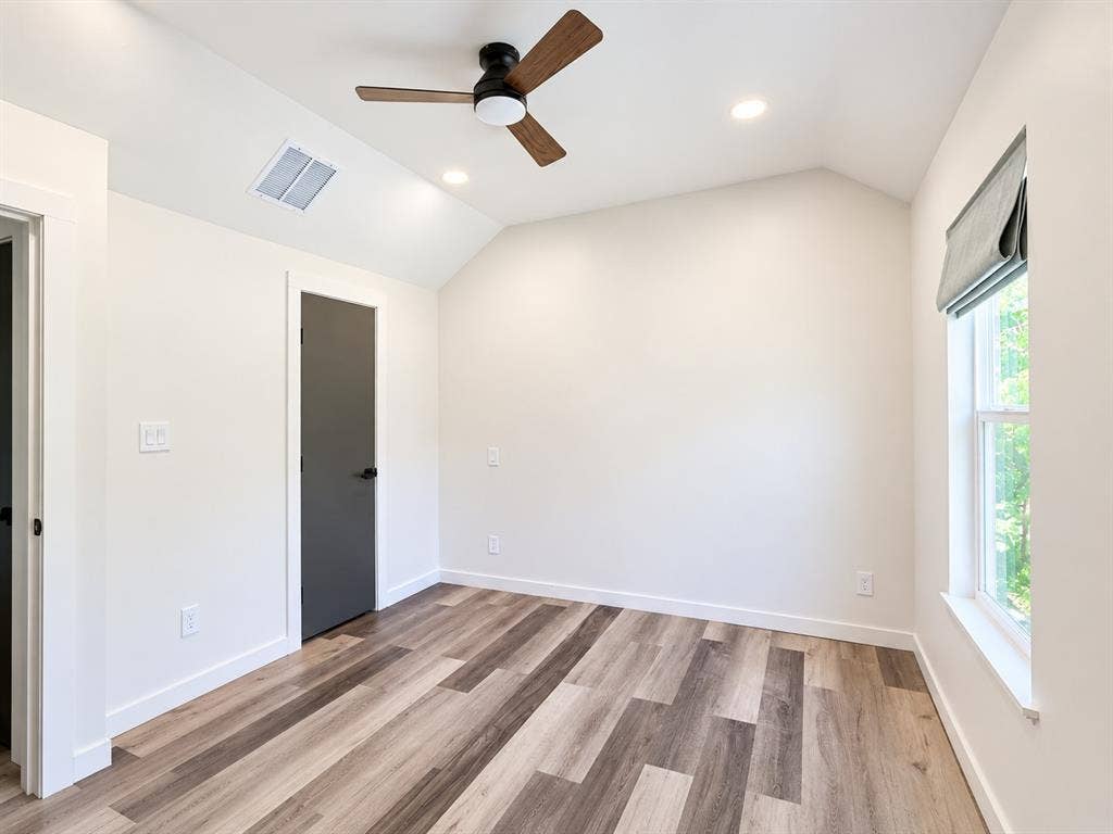 521 York Street, Athens, TX 75751 Vaulted ceiling with wood-finish ceiling fan, recessed lighting, wood-finish flooring, and a single window with a privacy shade