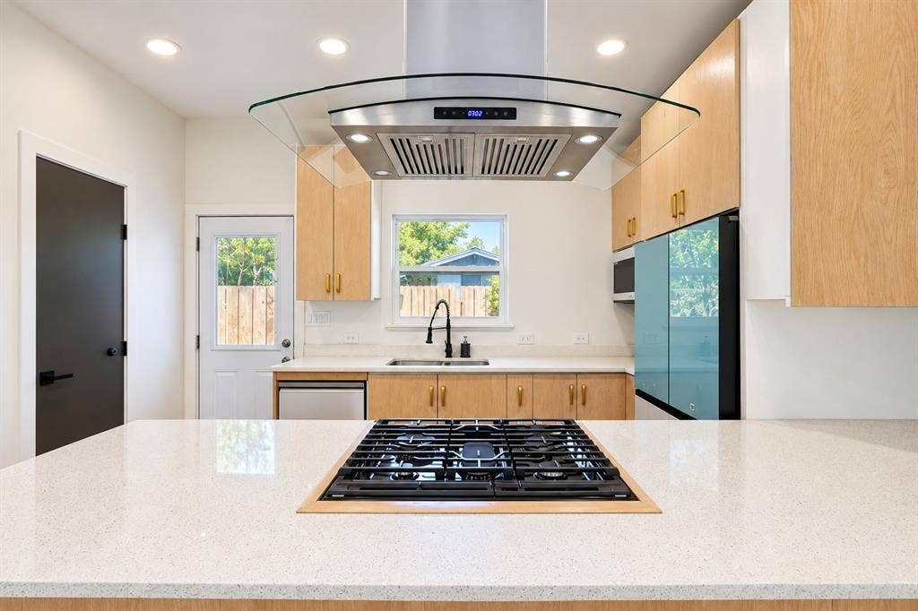 521 York Street, Athens, TX 75751 Kitchen featuring light wood cabinetry, white countertops, stainless steel appliances, and an integrated cooktop