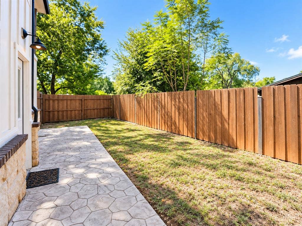 521 York Street, Athens, TX 75751 Private backyard with wood plank fencing, stamped concrete patio, and exterior wall sconce