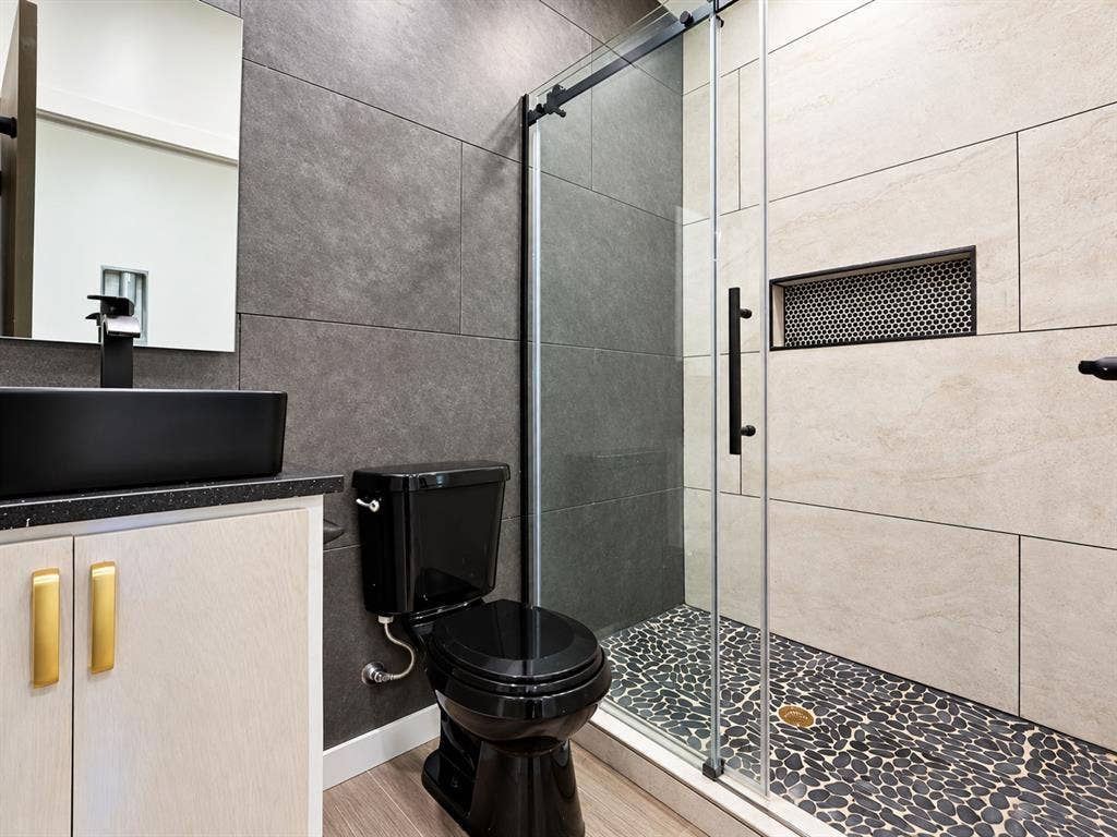 521 York Street, Athens, TX 75751 Walk-in shower with a mosaic pebble floor, tiled walls, and a recessed niche