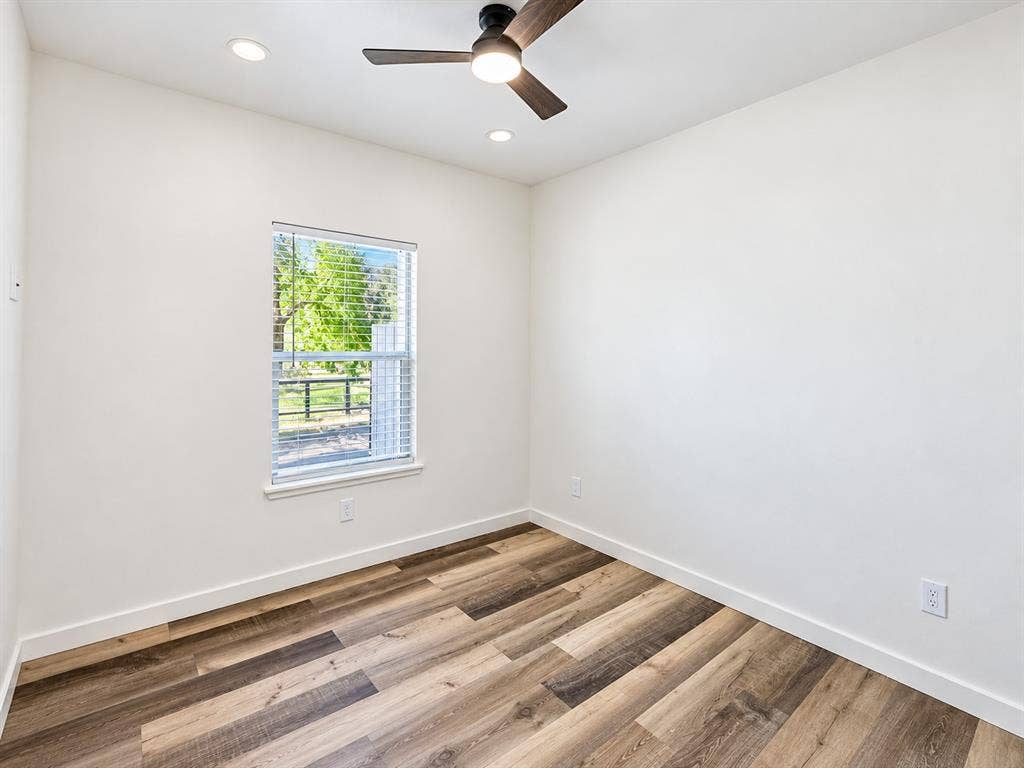 521 York Street, Athens, TX 75751 Wood-finish flooring, white walls, and a window with blinds