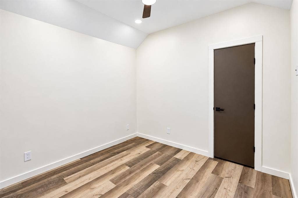 521 York Street, Athens, TX 75751 Vaulted ceiling with recessed lighting, wood-finish flooring, dark brown door with matte black hardware, and white trim throughout