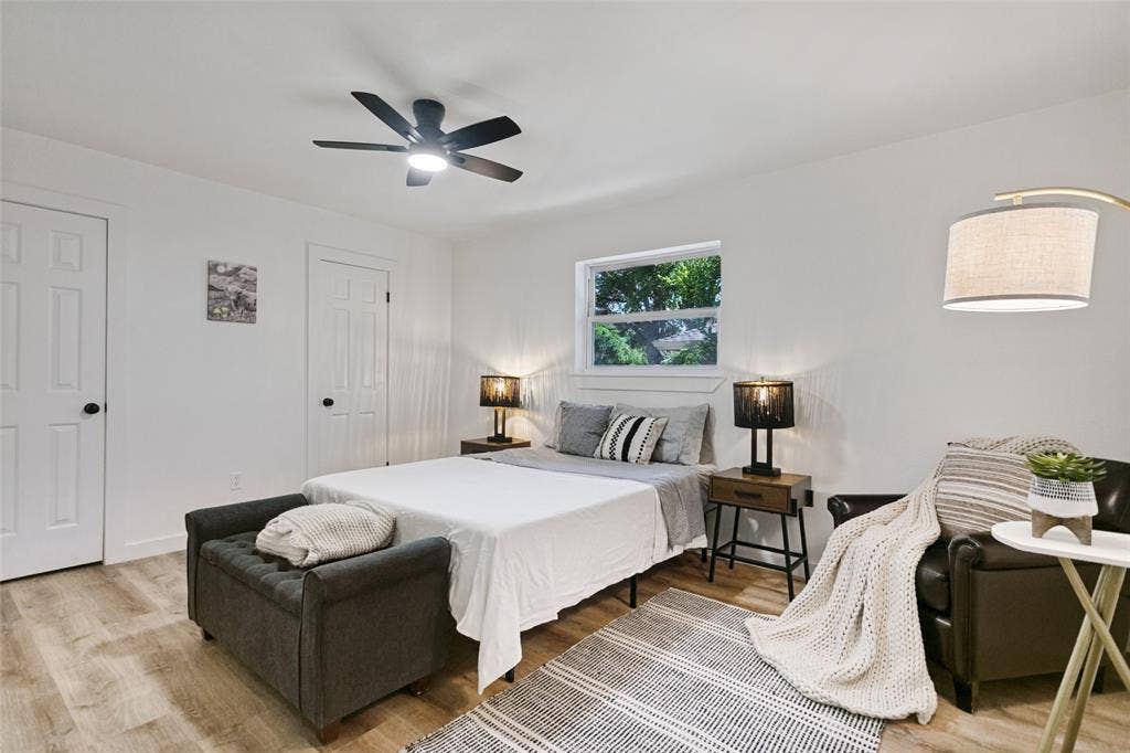 2704 Parkhaven Drive, Plano, TX 75075 Neutral white walls, wood-finish flooring, ceiling fan with integrated lighting, two panel doors, and a window providing natural illumination