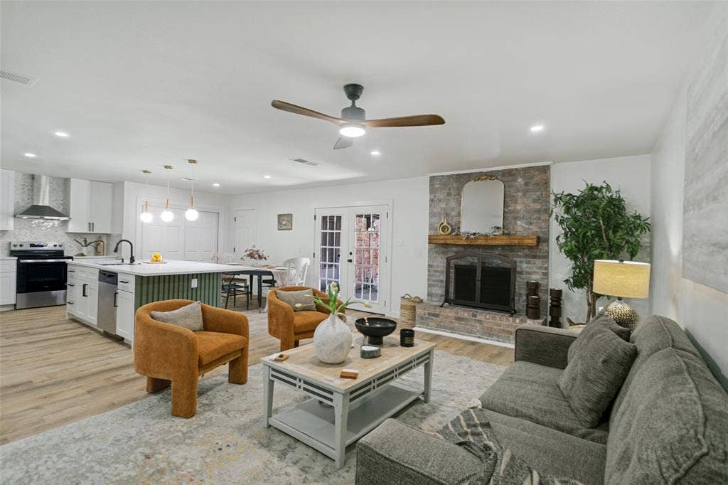 2704 Parkhaven Drive, Plano, TX 75075 Open-concept living space featuring a brick fireplace with a wood mantel, a ceiling fan, and recessed lighting