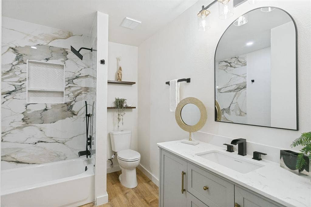 2704 Parkhaven Drive, Plano, TX 75075 Bathtub with marble-look tile surround and recessed shelving