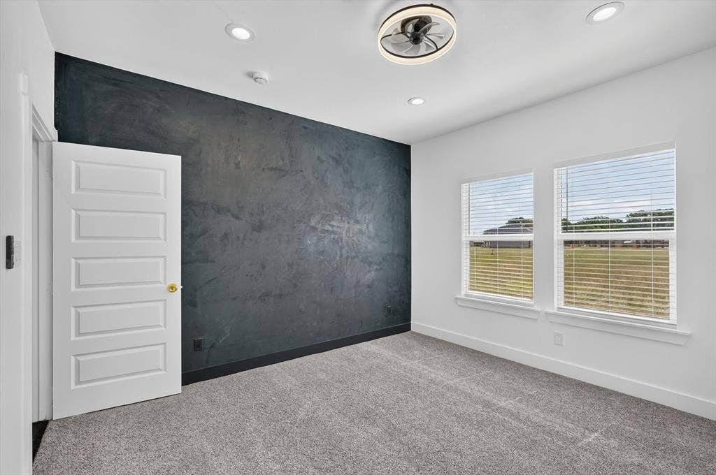 102 Shadywood Road, Trinidad, TX 75163 Textured accent wall, recessed lighting, ceiling fan with integrated light, two windows with blinds, and carpeted flooring