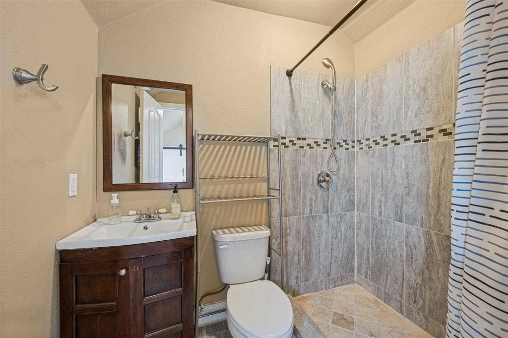 Corner vanity with a white basin and wood-finish cabinetry