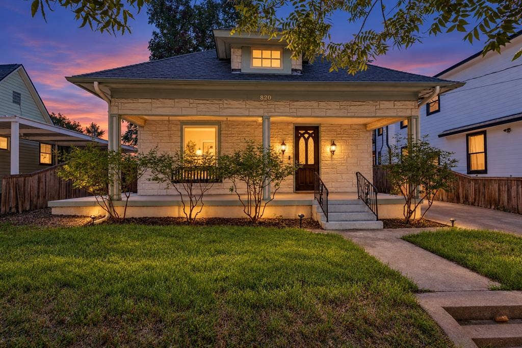 Stone facade featuring a covered front porch and decorative porch columns