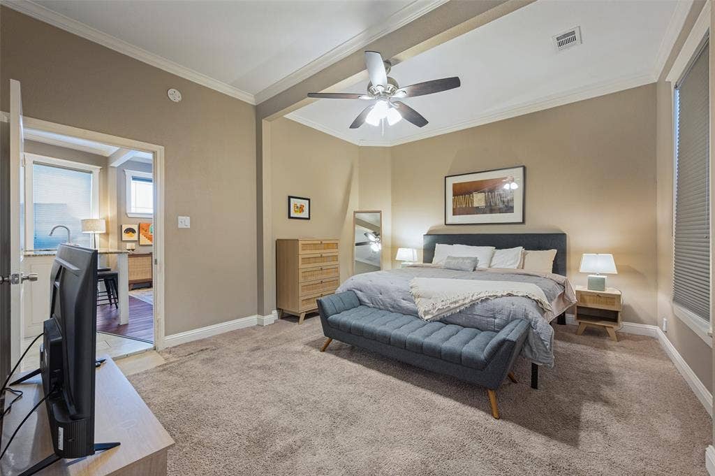 Recessed ceiling with crown molding, ceiling fan, and carpeted flooring