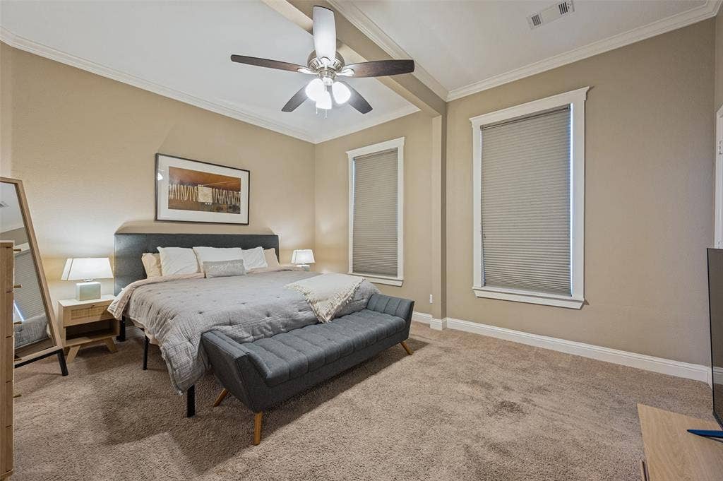 Vaulted ceiling with an integrated ceiling fan, two windows with blinds, and neutral-toned carpet flooring