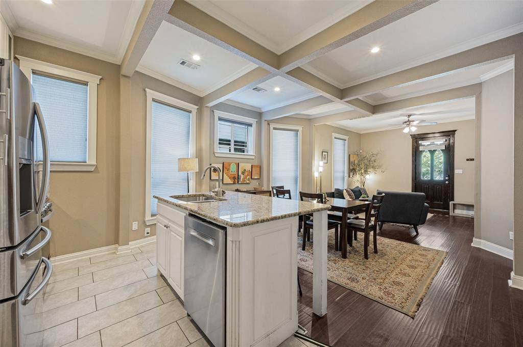 Open-concept main living area with coffered ceilings, recessed lighting, and a ceiling fan