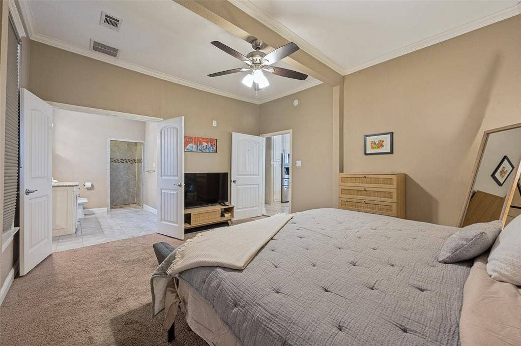 Vaulted ceiling with exposed beams, ceiling fan with integrated lighting, carpeted flooring, and crown molding