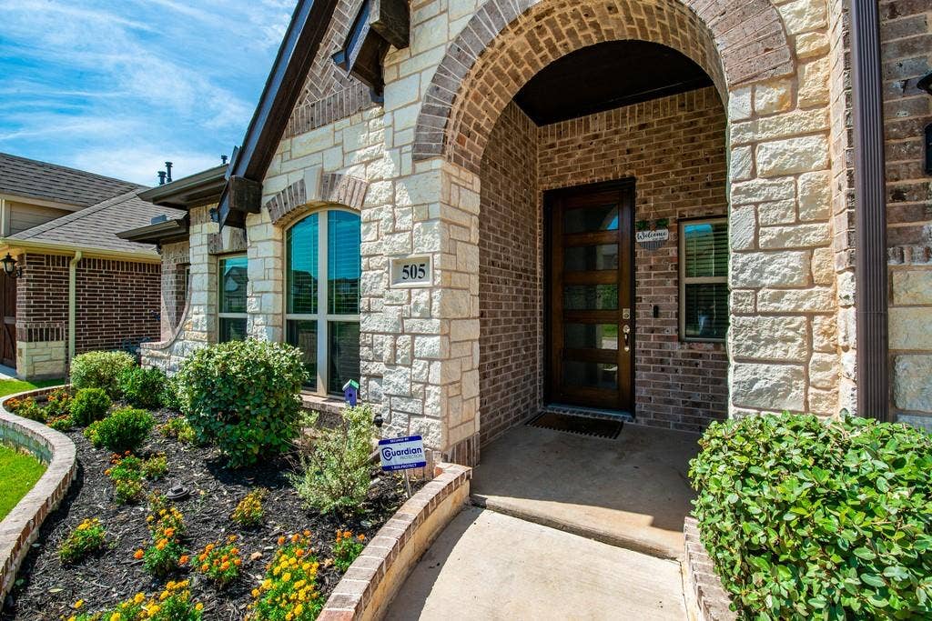 Brick and stone exterior with an arched entryway