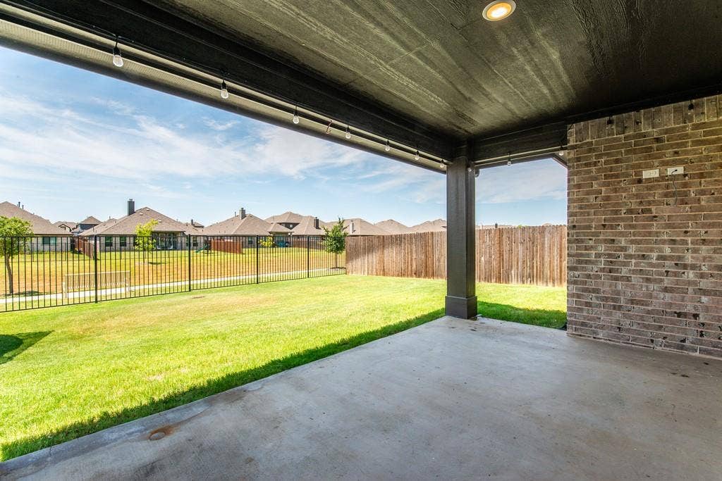 Covered patio with a concrete surface, brick wall, recessed lighting, and strung outdoor lights