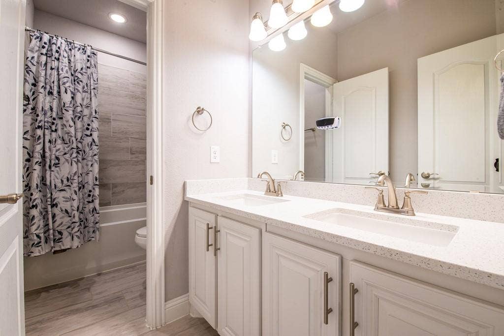Dual vanity with integrated sinks, light-toned countertops, and brushed nickel fixtures