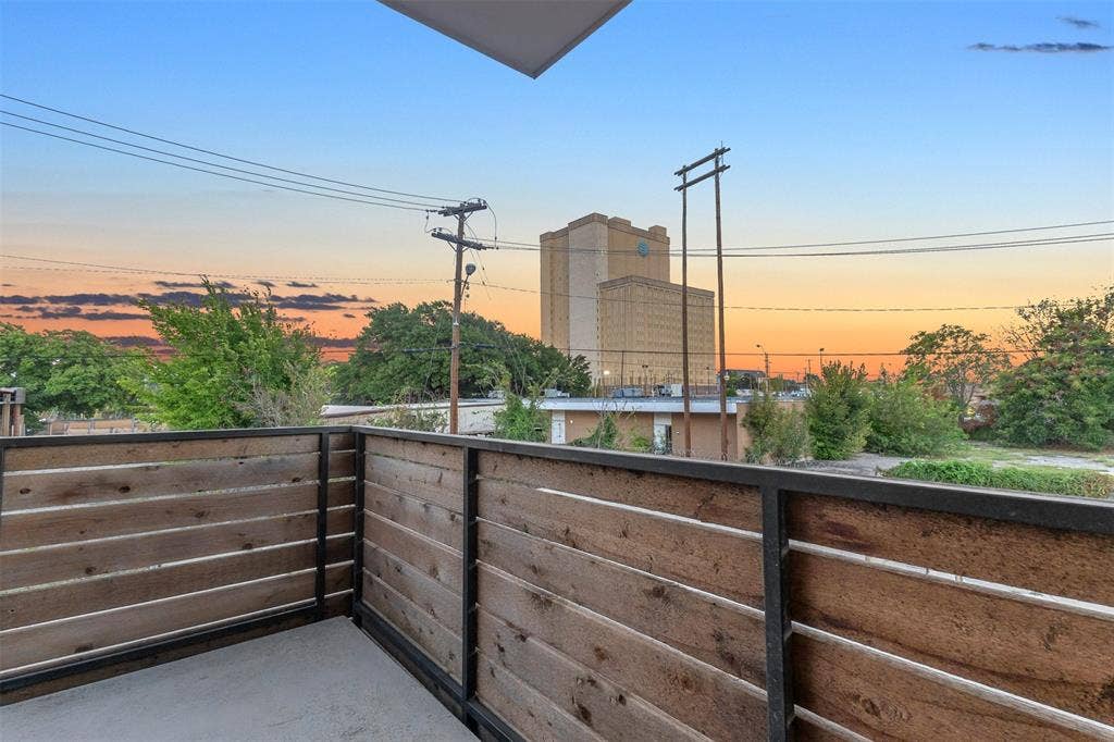 1510 N Washington Avenue, #703, Dallas, TX 75204 Wraparound balcony with horizontal wood rails, a concrete deck and open sunset views over the neighborhood