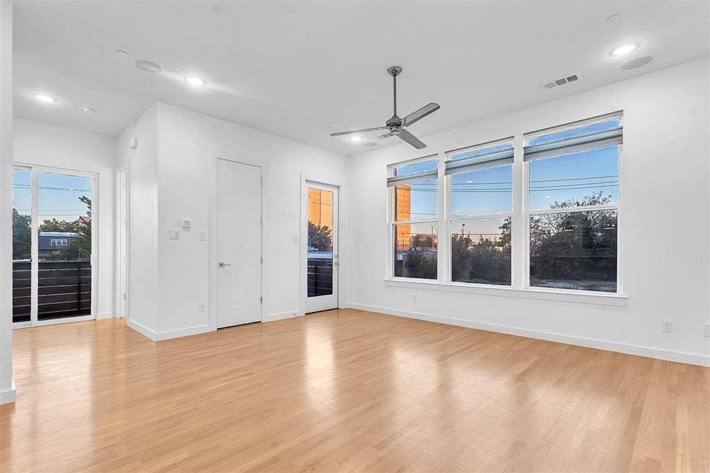 1510 N Washington Avenue, #703, Dallas, TX 75204 Living area with three large windows, two glass doors to the wraparound balcony and in-ceiling speakers