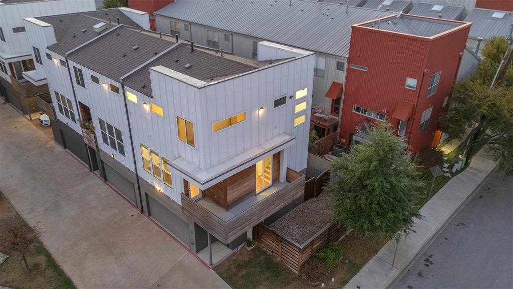 1510 N Washington Avenue, #703, Dallas, TX 75204 Aerial view of the end-unit condo showing the wraparound balcony, rooflines, fenced side yard and shade tree