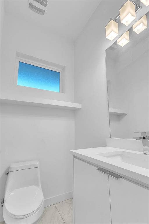 1510 N Washington Avenue, #703, Dallas, TX 75204 Powder room with a white vanity, one-piece toilet, frosted window and display ledge in this East Dallas condo