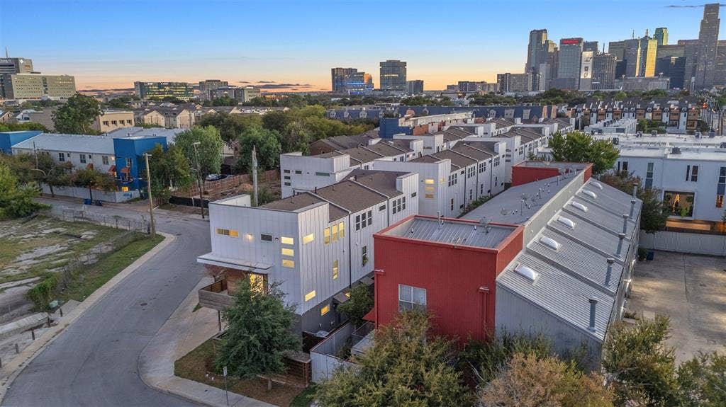 1510 N Washington Avenue, #703, Dallas, TX 75204 Aerial view of the townhome-style condo community at dusk with the Downtown Dallas skyline on the horizon