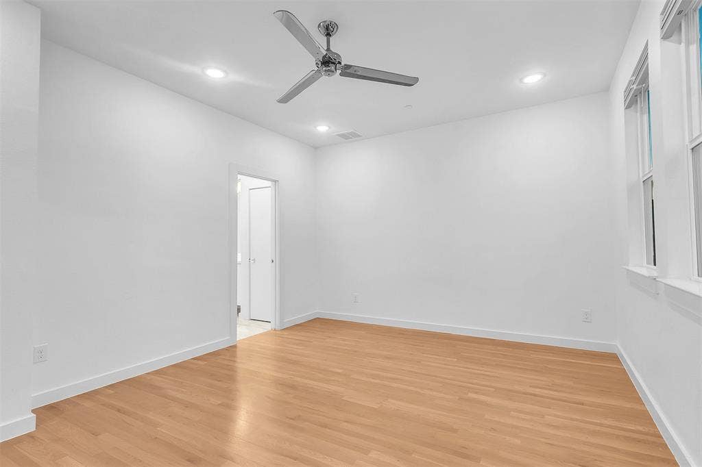 1510 N Washington Avenue, #703, Dallas, TX 75204 Bedroom view toward the doorway to the adjoining bath area, with recessed lights and a chrome ceiling fan