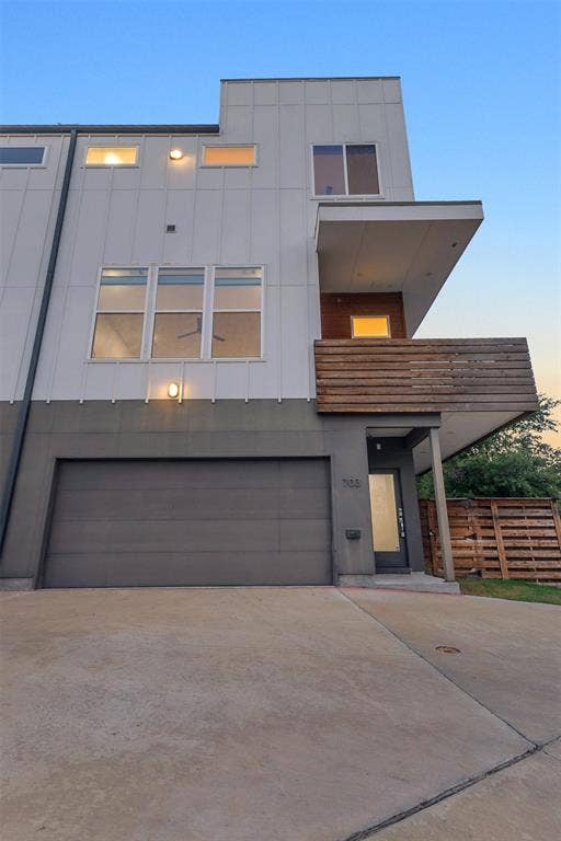 1510 N Washington Avenue, #703, Dallas, TX 75204 Front of unit 703 with a 2-car garage, glass front door, covered entry and wood balcony above, Dallas TX
