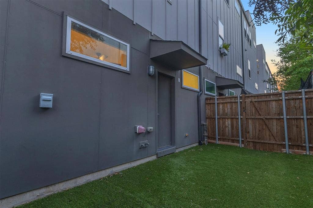 1510 N Washington Avenue, #703, Dallas, TX 75204 Private turf back yard with a covered rear entry door and a wood privacy fence at this Dallas condo