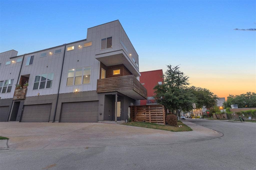 1510 N Washington Avenue, #703, Dallas, TX 75204 Street view of the corner end unit with board and batten siding, wood balcony, garage and landscaped side yard