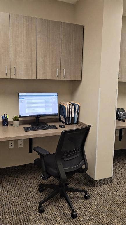 1675 Republic Parkway, #104, Mesquite, TX 75150 Built-in desk with overhead cabinetry, wall-mounted desk, and patterned carpet flooring
