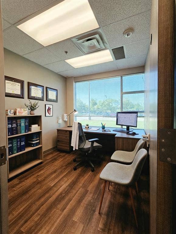 1675 Republic Parkway, #104, Mesquite, TX 75150 Wood-finish flooring with a built-in desk, shelving unit, and large window with blinds