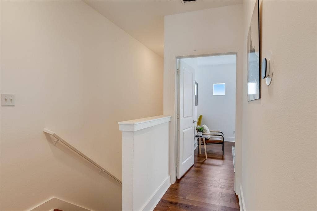 Corridor featuring an upstairs landing, wood finished floors, and baseboards