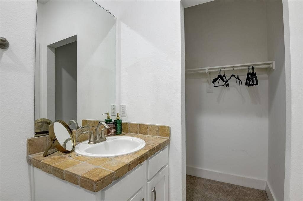 Bathroom with vanity and a spacious closet