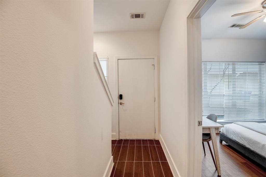 Hallway with dark wood finished floors, healthy amount of natural light, and baseboards