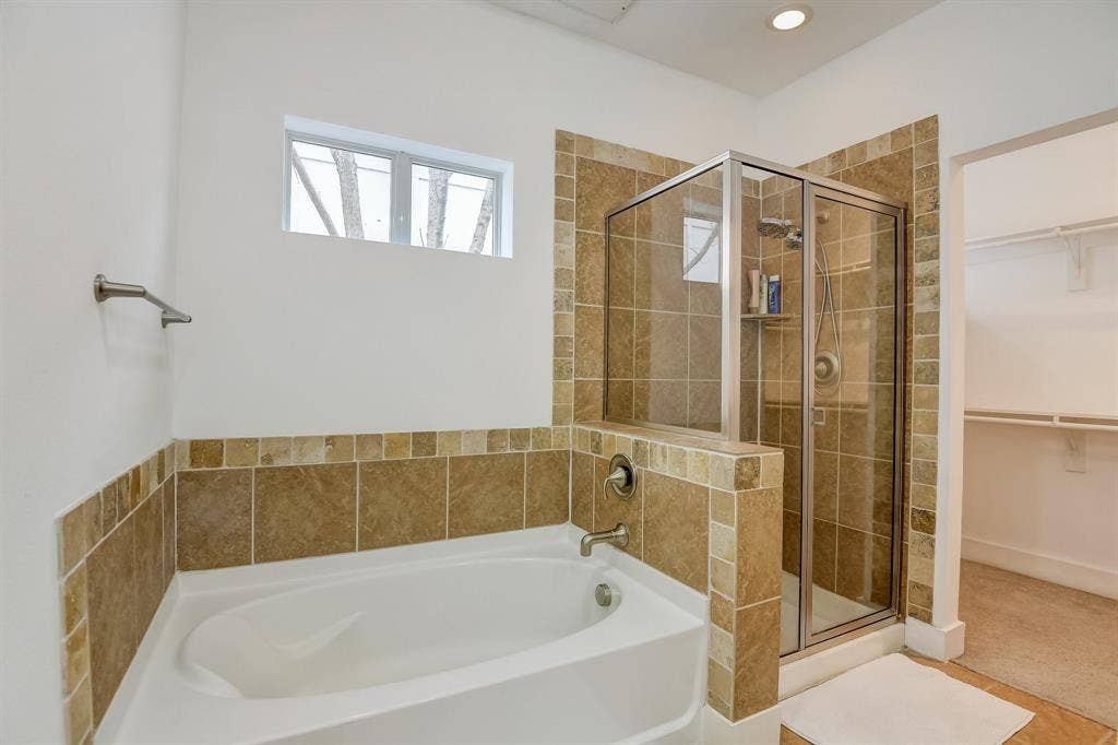 Full bath featuring a garden tub, a shower stall, a spacious closet, and recessed lighting