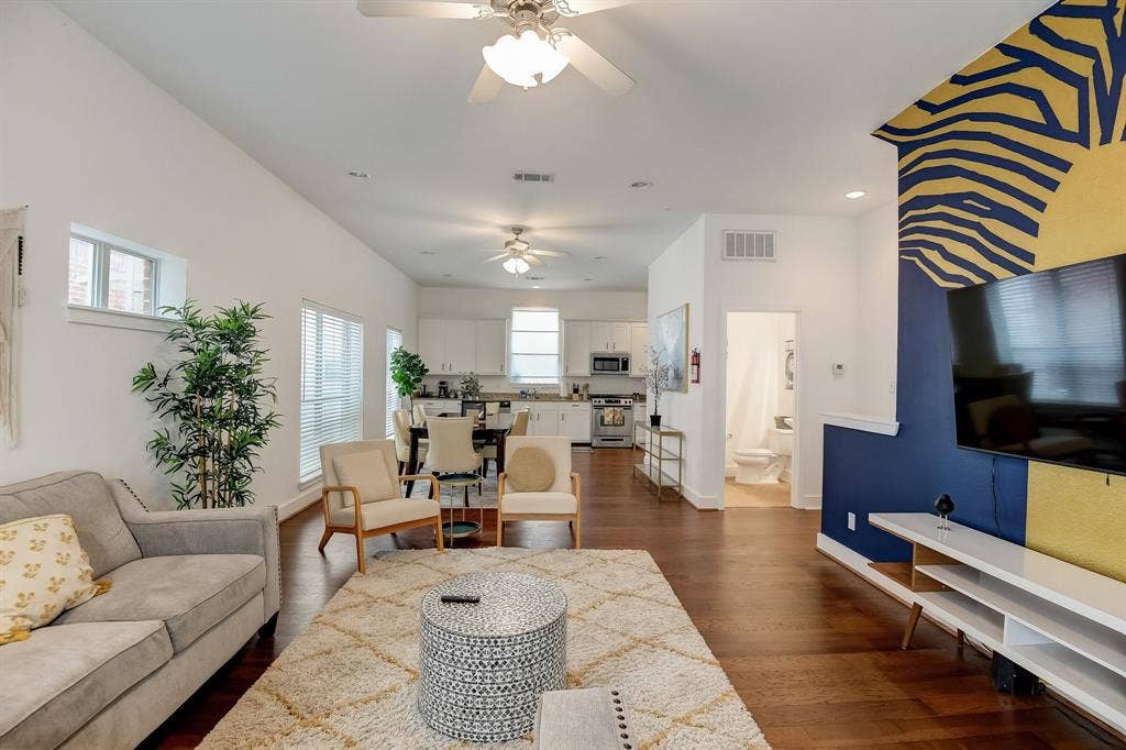 Living room with ceiling fan, baseboards, dark wood-type flooring, and recessed lighting