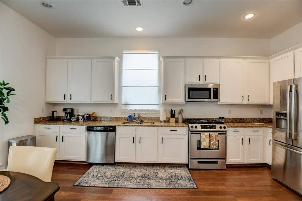 Kitchen featuring stainless steel appliances, a sink, white cabinetry, and recessed lighting