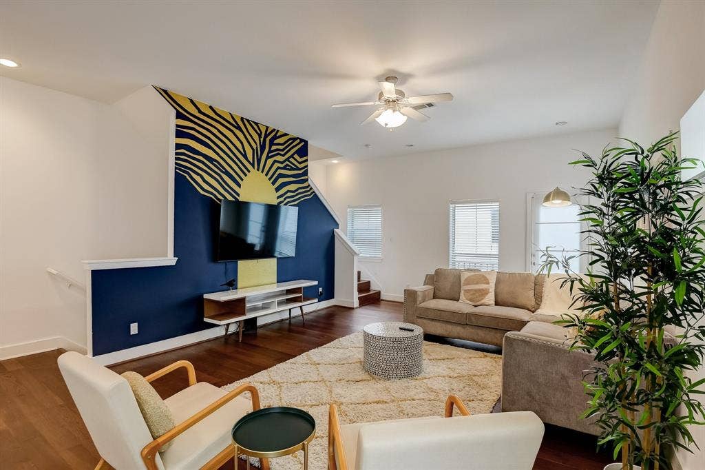 Living room featuring ceiling fan, stairs, dark wood-type flooring, baseboards, and recessed lighting