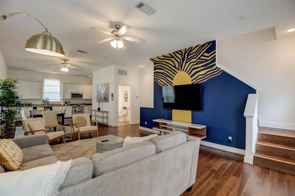 Living room with ceiling fan, baseboards, dark wood-style flooring, recessed lighting, and stairway