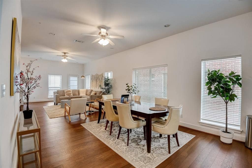 Dining room with dark wood-style floors, ceiling fan, and baseboards