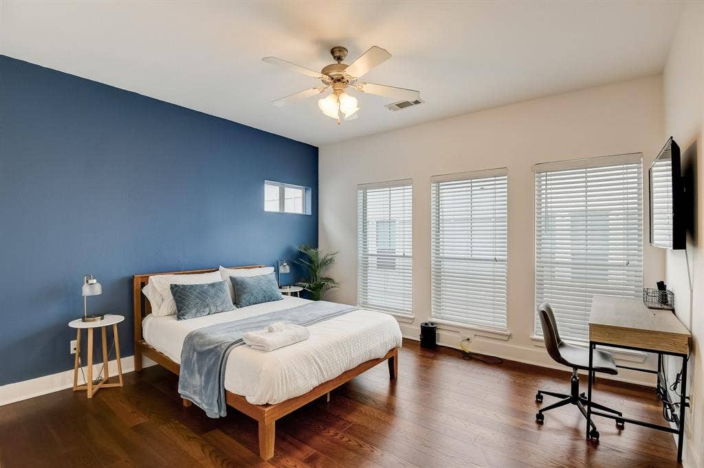 Bedroom with an office area, wood finished floors, baseboards, and ceiling fan