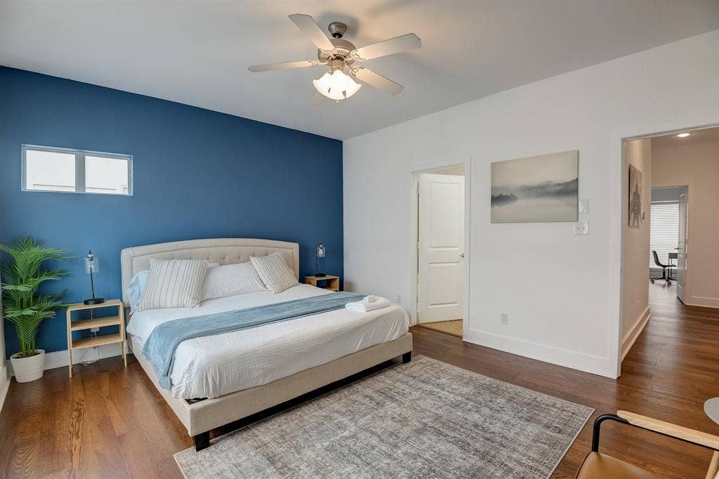 Bedroom with baseboards, multiple windows, and wood finished floors