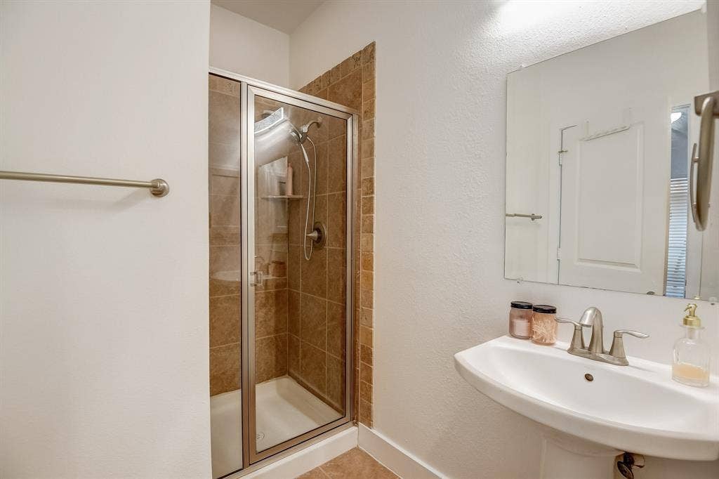 Bathroom featuring a sink, a stall shower, and tile patterned floors