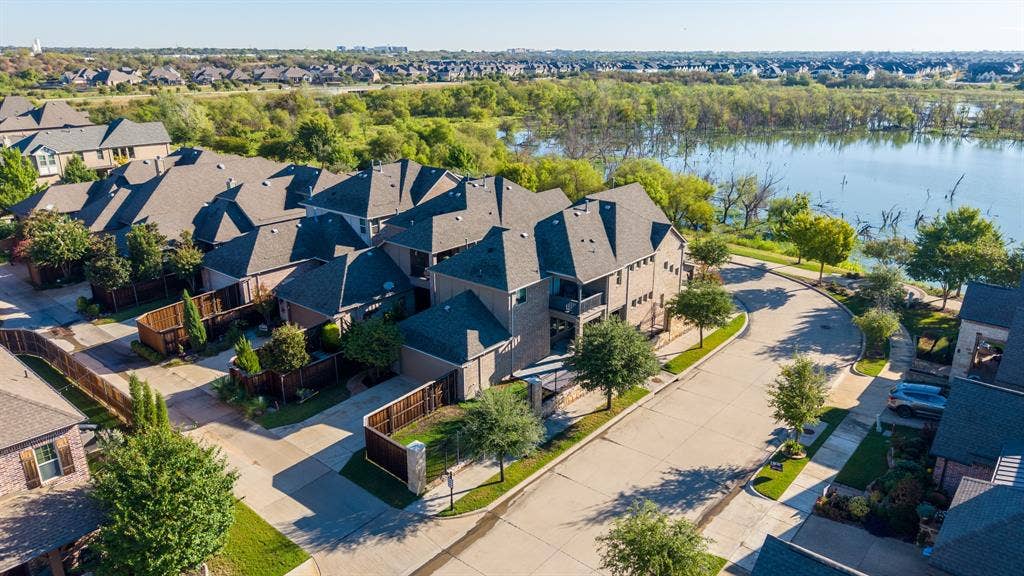 Neighborhood featuring a residential street, private fenced yards, and a body of water with surrounding greenery