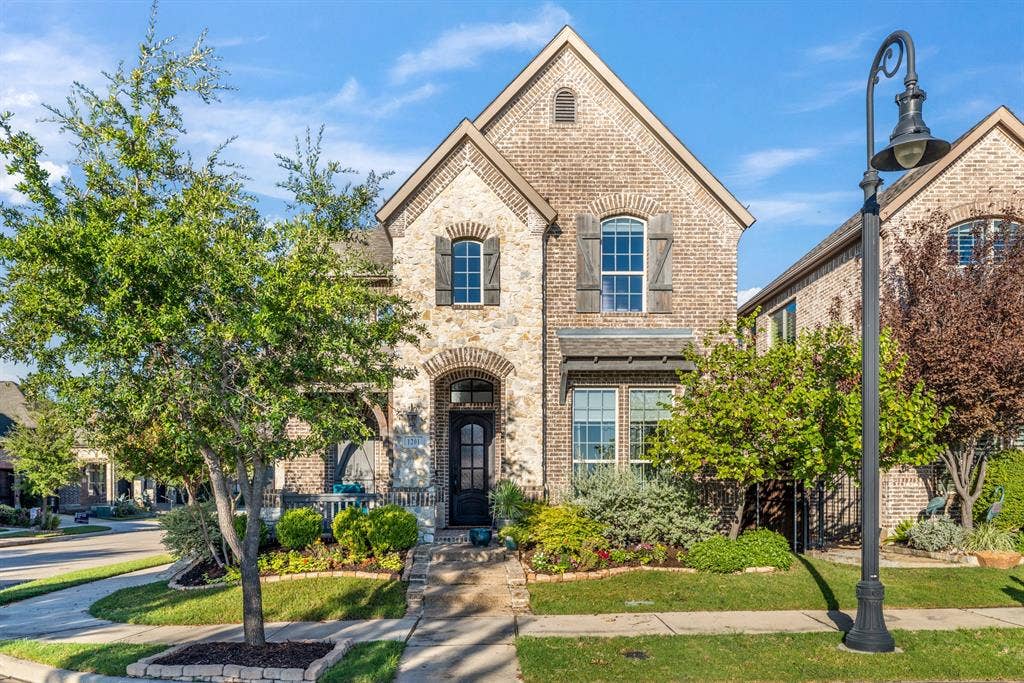 Brick and stone exterior with a prominent arched entry, complete with a dark-paneled front door