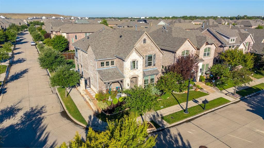 Corner lot residence featuring a brick exterior, multiple gables, and a covered entry porch