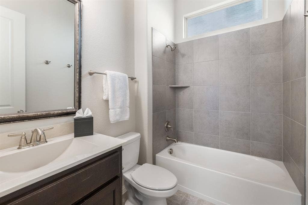 Downstairs bathroom with a dark wood-finish vanity, white countertop, and brushed nickel fixtures