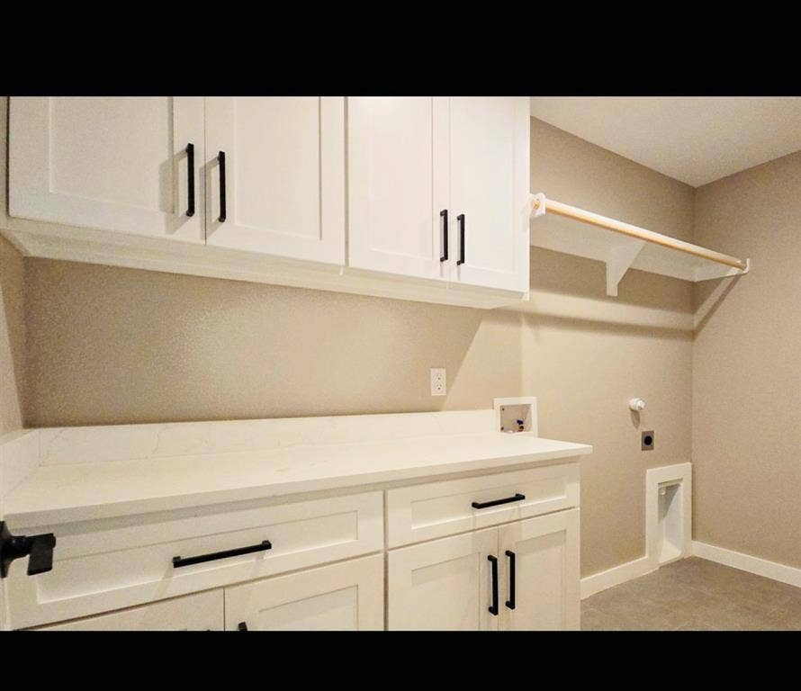 2821 Avenue L, Fort Worth, TX 76105 White shaker-style cabinetry with matte black hardware, white countertop, and a built-in hanging rod