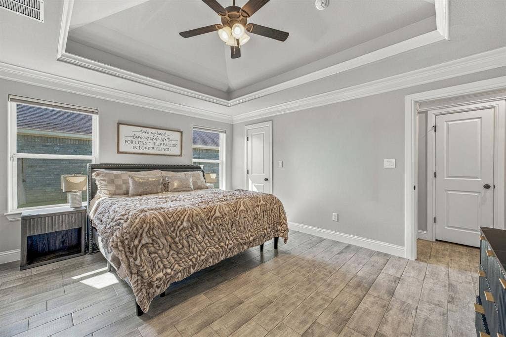 601 Violet Drive, Tolar, TX 76476 Tray ceiling with crown molding, ceiling fan, two windows with blinds, wood-finish flooring, and white interior doors