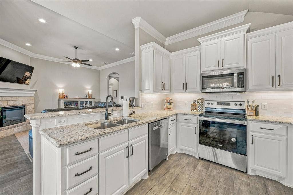 601 Violet Drive, Tolar, TX 76476 Kitchen featuring white cabinetry, granite countertops, stainless steel appliances, and wood-finish flooring