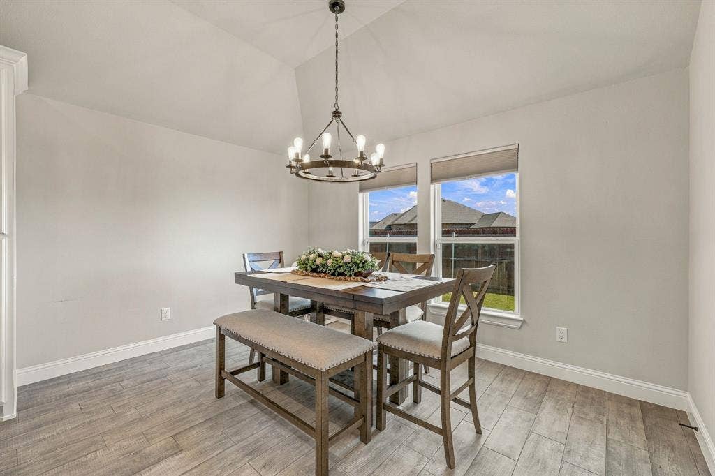 601 Violet Drive, Tolar, TX 76476 Vaulted ceiling with an iron chandelier, wood-finish flooring, and dual windows